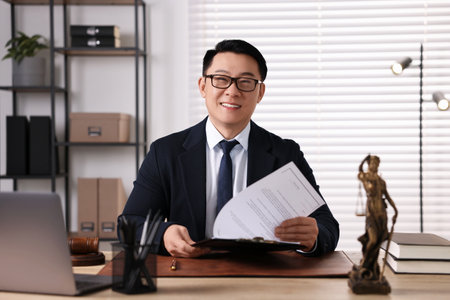 Happy notary working at wooden table in officeの写真素材