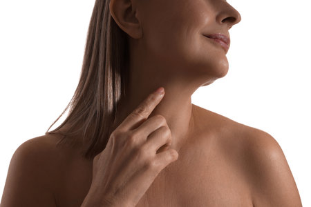 Mature woman touching her neck on white background, closeupの写真素材