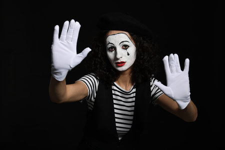 Young woman in mime costume posing on black backgroundの写真素材