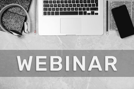 Webinar. Headphones, laptop, stationery and smartphone on gray marble table, flat layの写真素材