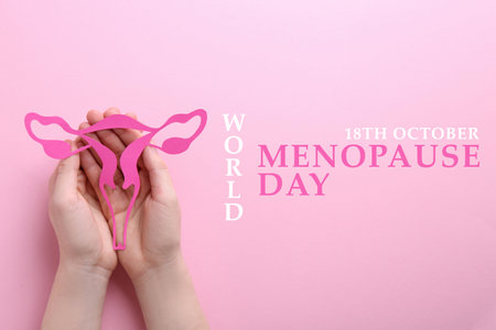 World Menopause Day - October, 18. Woman holding paper uterus on pink background, top viewの写真素材