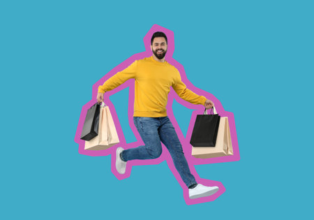 Happy man with shopping bags jumping on light blue backgroundの写真素材