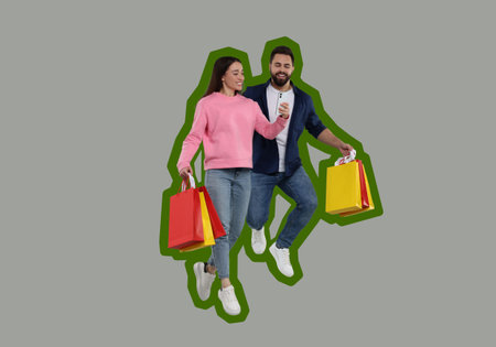 Happy couple with shopping bags looking at smartphone and jumping on gray backgroundの写真素材