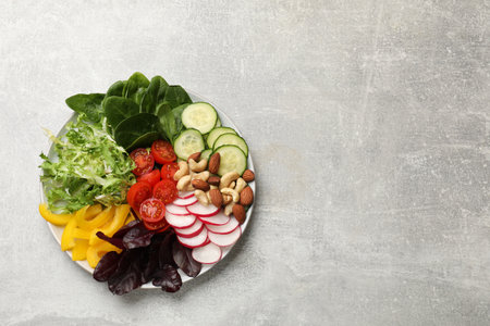 Balanced diet and vegetarian foods. Plate with different delicious products on gray table, top view. Space for textの写真素材