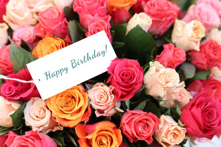 Bouquet of beautiful roses with Happy Birthday card, closeupの写真素材