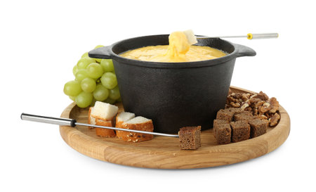 Fondue with tasty melted cheese, forks, grapes and pieces of bread isolated on whiteの写真素材