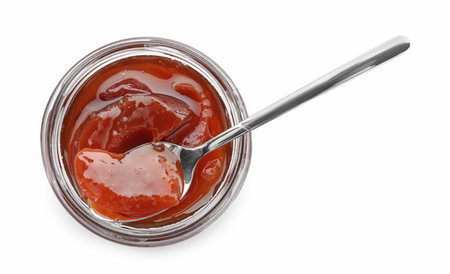 Tasty homemade quince jam in jar and spoon isolated on white, top viewの写真素材