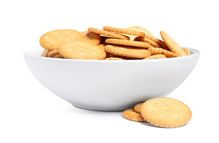 Tasty crackers in bowl isolated on whiteの写真素材