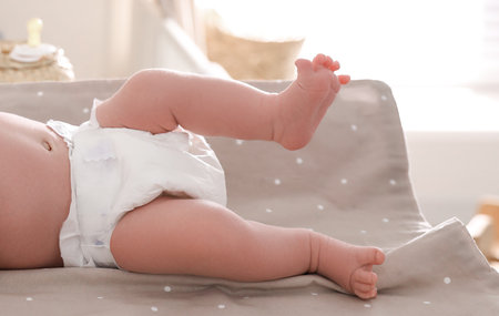 Cute little baby on changing table in room