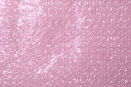 Transparent bubble plastic wrap on pink background, top view