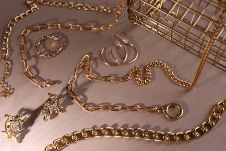 Metal chains and other different accessories on light brown background, above view. Luxury jewelryの写真素材