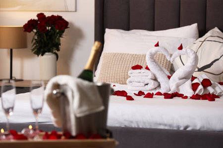 Honeymoon. Swans made with towels and beautiful rose petals on bedの写真素材
