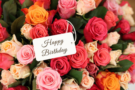 Bouquet of beautiful roses with Happy Birthday card, top viewの写真素材