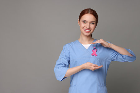 Mammologist with pink ribbon on gray background, space for text. Breast cancer awarenessの写真素材
