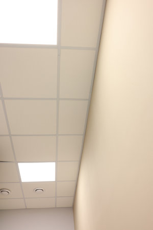 White ceiling with PVC tiles and lighting indoors, bottom view