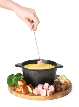 Woman dipping piece of ham into fondue pot with tasty melted cheese on white background, closeupの写真素材