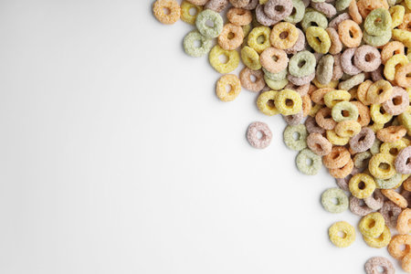 Tasty cereal rings on white background, flat lay. Space for text
