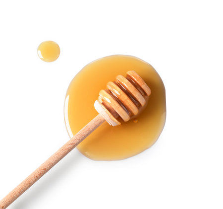 Wooden dipper and fresh honey on white background, top viewの写真素材