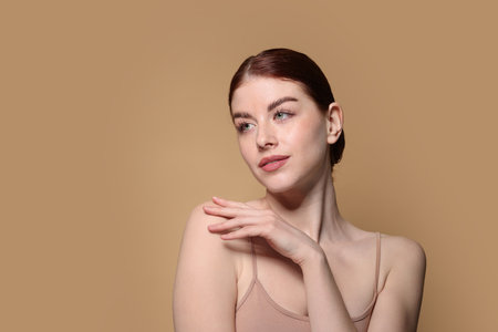 Portrait of beautiful woman on beige background. Space for textの写真素材