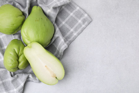 Cut and whole chayote on gray table, top view. Space for textの写真素材