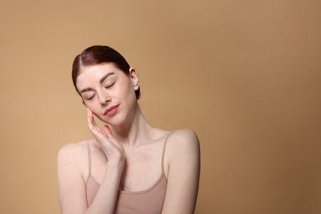 Portrait of beautiful woman on beige background. Space for textの写真素材