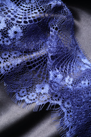 Beautiful blue lace on black fabric, top viewの写真素材