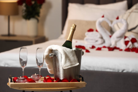 Honeymoon. Sparkling wine and glasses on wooden table in roomの写真素材