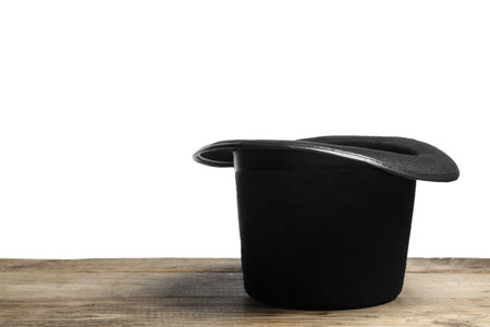 Magician's hat on wooden table against white background