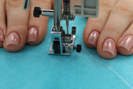Seamstress working with sewing machine, selective focus