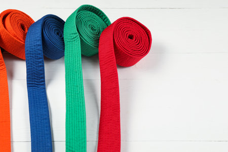 Colorful karate belts on wooden background, space for textの写真素材