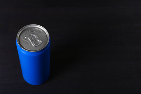 Energy drink in blue can on black wooden table, space for textの写真素材