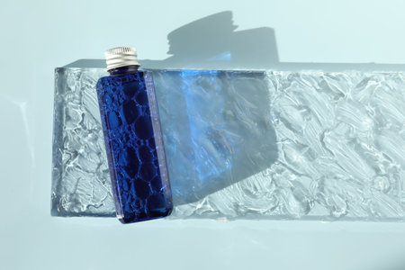 Bottle of cosmetic product on light blue background, top viewの写真素材