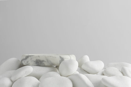 Presentation for product. Stone podium and white pebbles on light background. Space for textの写真素材