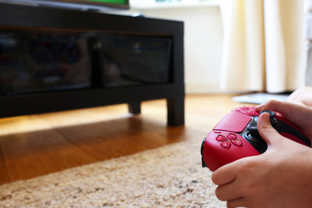 Child playing video games with controller at home, closeup. Space for text