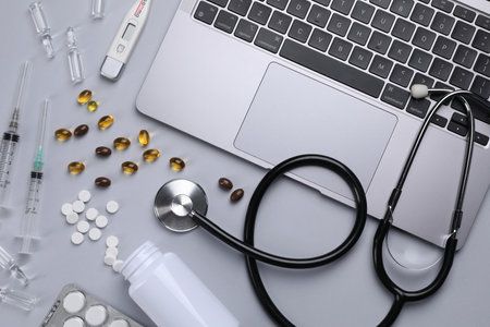 Flat lay composition with laptop and medical supplies on light gray backgroundの写真素材