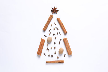 Christmas tree made of different spices on white table, flat lay