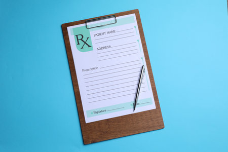 Clipboard with medical prescription form and pen on light blue background, top viewの写真素材