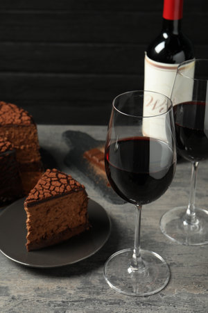 Delicious chocolate truffle cake and red wine on gray textured tableの写真素材