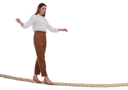 Businesswoman walking rope against white background. Risk or balance conceptの写真素材