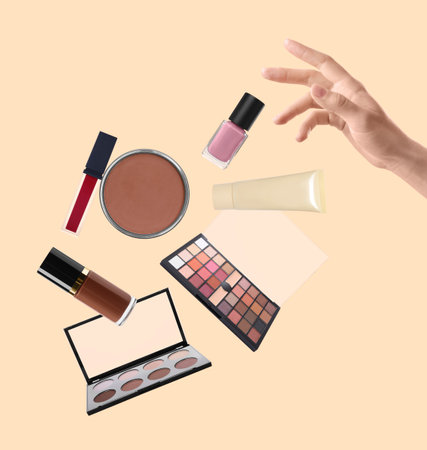 Woman making decorative cosmetics levitate on beige background, closeup. Makeup productsの写真素材
