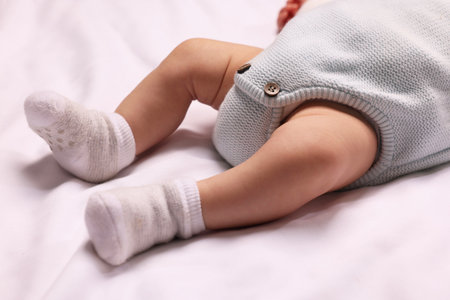 Newborn baby lying on white blanket, closeup
