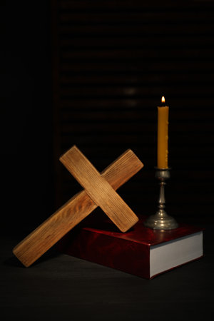 Church candle, Bible and wooden cross on tableの写真素材