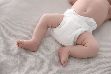 Cute little baby in diaper lying on bed, closeupの写真素材