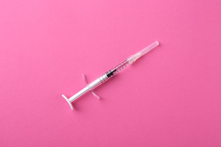 Injection cosmetology. One medical syringe on pink background, top viewの写真素材