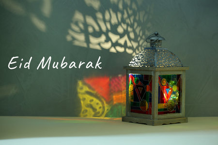Eid Mubarak greeting card. Arabic lantern on light surface at nightの写真素材