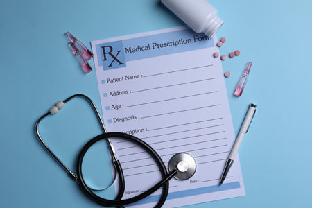Medical prescription form, stethoscope, ampoules and pills on light blue backgroundの写真素材