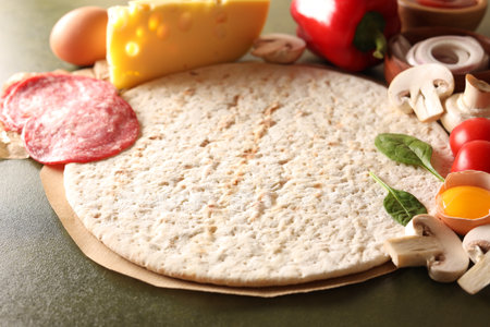 Pizza base and products on green textured table, closeupの写真素材
