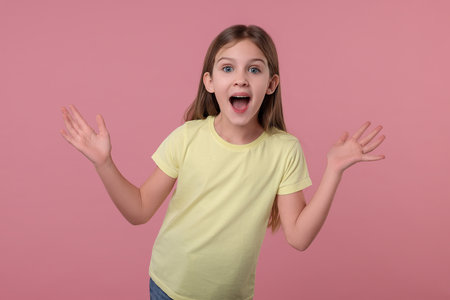 Portrait of surprised girl on pink backgroundの写真素材