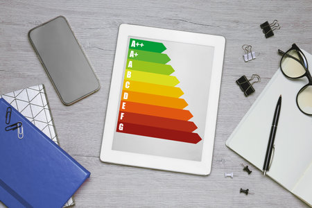 Energy efficiency rating on tablet display. Flat lay composition on tableの写真素材