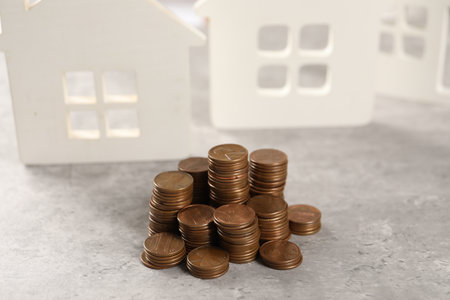 House models and stacked coins on gray table, selective focusの写真素材